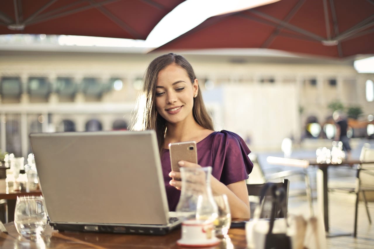 5 diferenças entre portfolios eficientes e portfolios ruins: mulher vestindo roxo sentada na cadeira enquanto segura telefone.